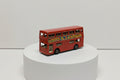Red toy double-decker bus with colorful graphics on a white background
